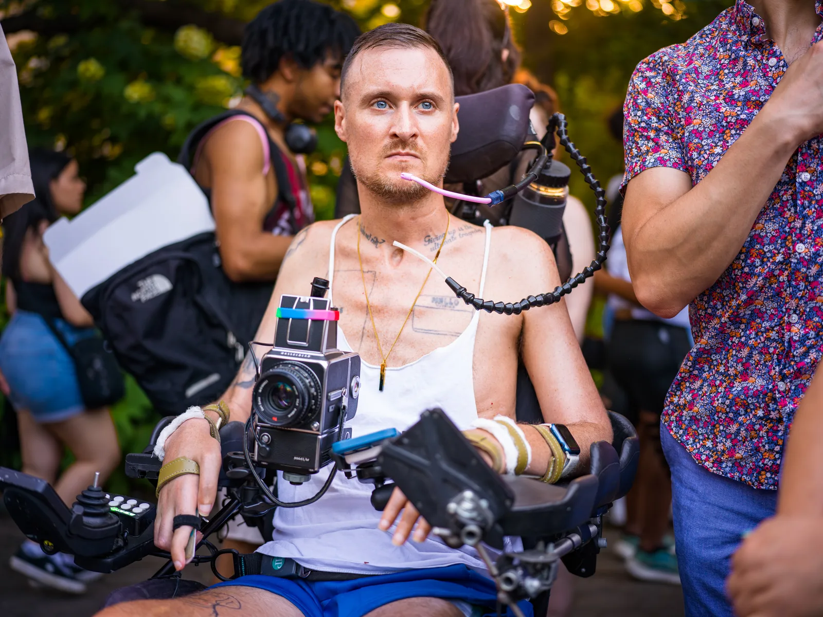 Robert Andy Coombs seated in his power wheelchair with a medium-format camera mounted in front of him.