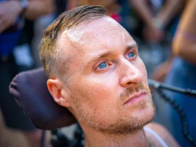 Close-up of a pale person with blue eyes looking upward.